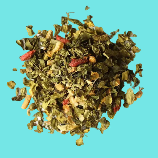 Heap of green and red dried herbs on a turquoise background.